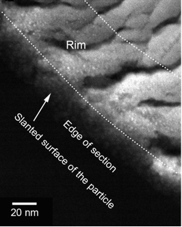 شکل ۳. تصویر میکروسکوپ الکترونی عبوری روبشی زمینه‌تاریک(۴) که از یک دانه‌ی برگشتی سیارک ایتوکاوا گرفته شده است. در این تصویر مرز دانه و محدوده‌ی مورد مطالعه بر روی دانه با خط‌چین مشخص شده است. منبع: T. Noguchi et al. Science 2011;333:1121-1125